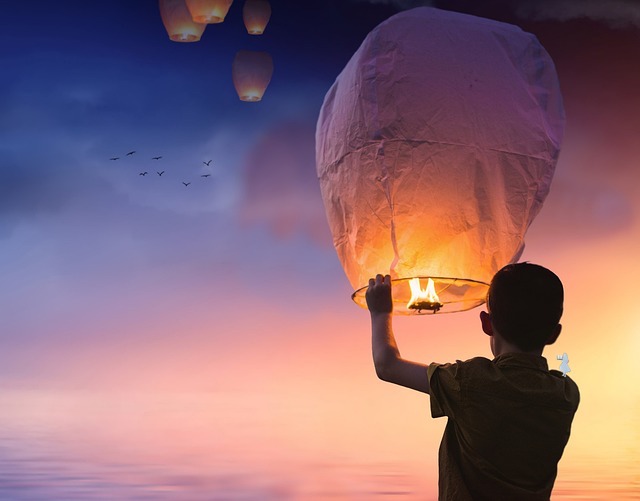 child-releases-a-light-paper-lantern-in-twilight